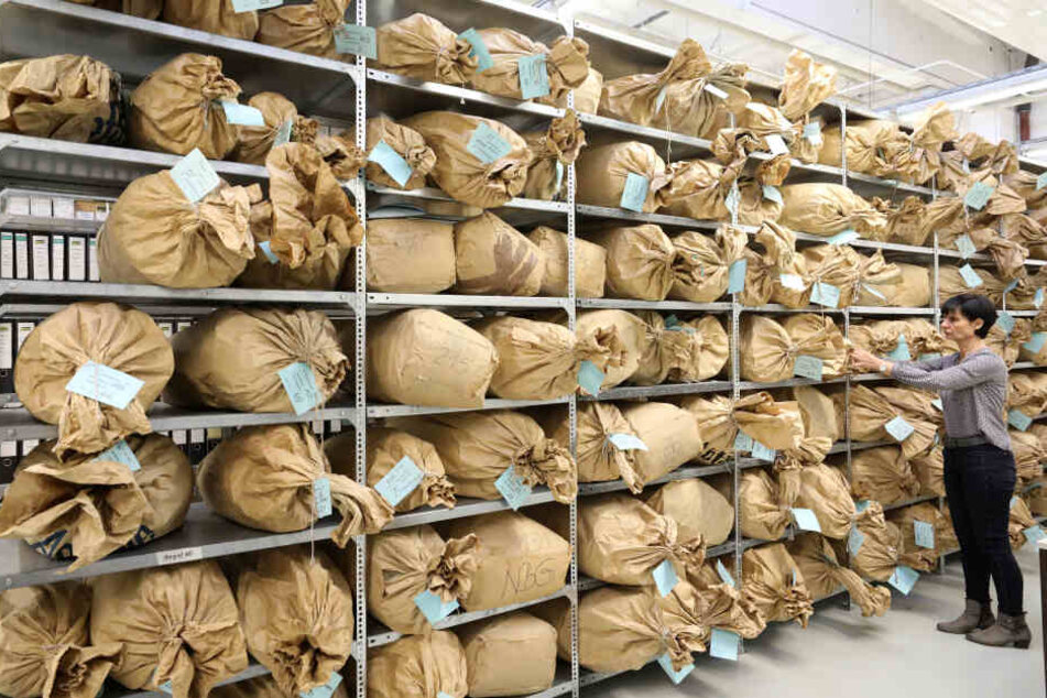 Heike Thieme, Leiterin des Archivs, steht in der Außenstelle Neubrandenburg der Behörde des Bundesbeauftragten für die Stasi-Unterlagen BStU vor Regalen mit Papiersäcken, die mit zerrissenen Akten gefüllt sind.
