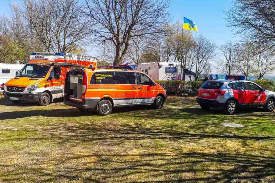 Rettungswagen stehen auf einer Wiese des nahegelegenen Campingplatzes.