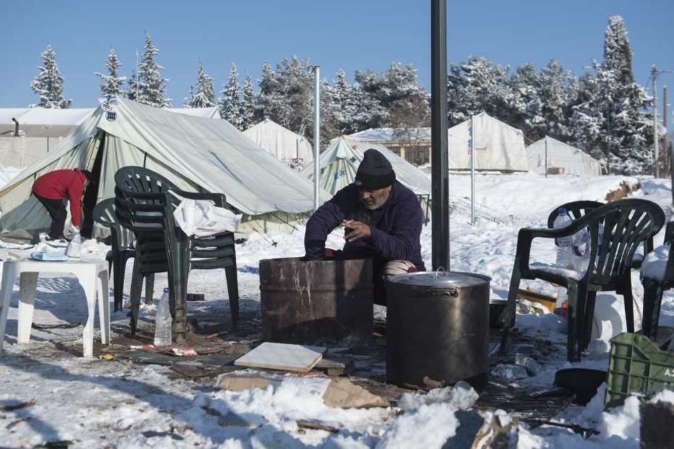 Ein Flüchtling aus Pakistan versucht in einem schneebedeckten Flüchtlingslager nahe des Dorfes Vagiohori, etwa 45 Kilometer östlich von Thessaloniki, Feuer zu entfachen.