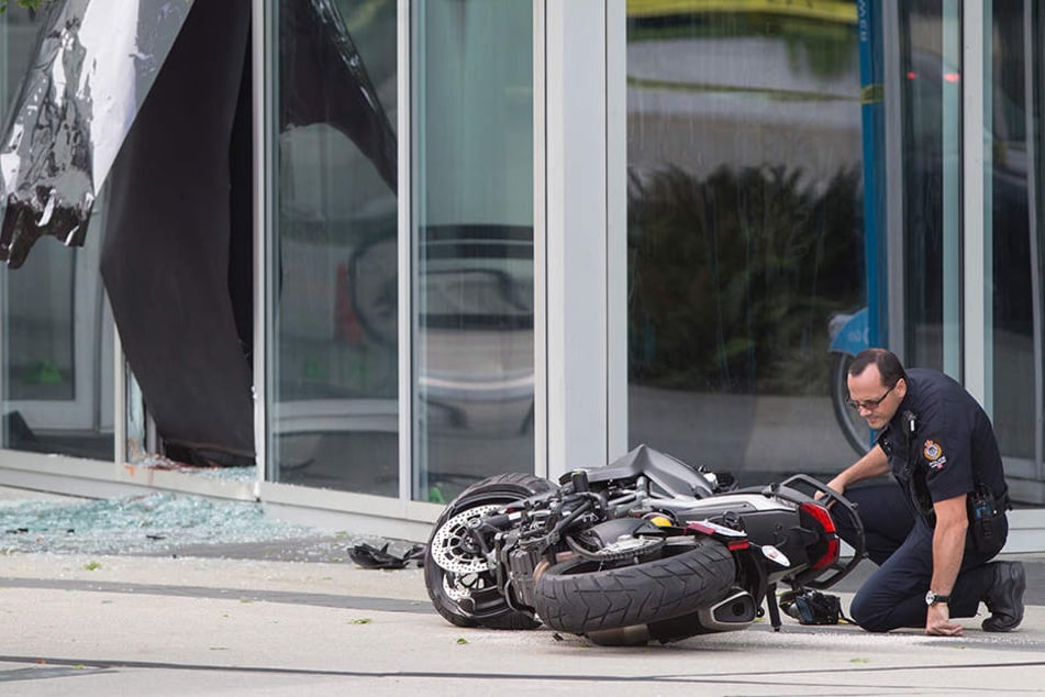 Ein Polizist untersucht das Motorrad einer Stuntfrau. Sie starb nach einem Unfall am Set.