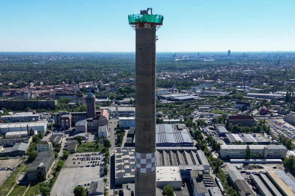 Mit Hilfe eines sogenannten Spinnenbaggers wird aktuell ein 150 Meter hoher Schornstein auf dem Gelände der ehemaligen Gusswerke Leipzig abgetragen.