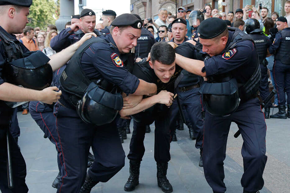 Polizisten halten einen Mann während der Kundgebung im Zentrum von Moskau fest.