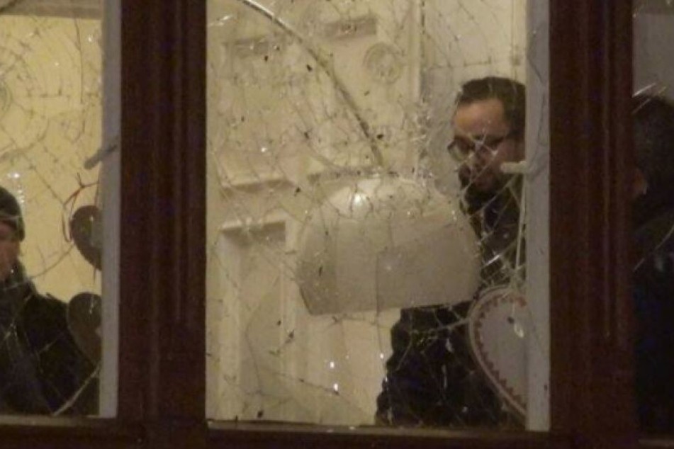Ein Foto, das kurz nach dem Anschlag aufgenommen wurde. Sebstian Gemkow steht hinter der zerstörten Fensterscheibe und betrachtet die Schäden.