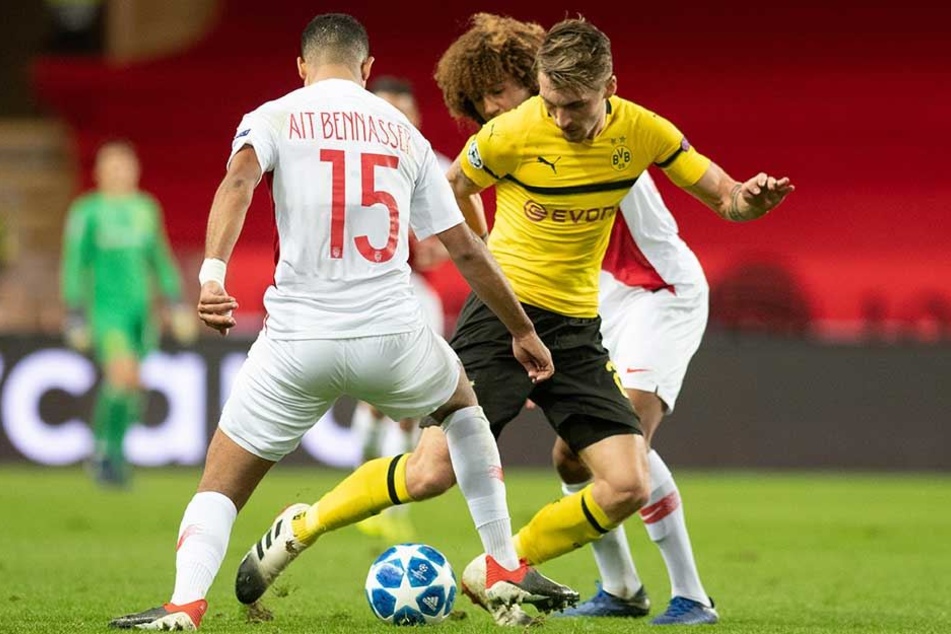 Maximilian Philipp (M) und Youssef Ait Bennasser (l) und Han-Noah Massengo von Monaco kämpfen um den Ball.