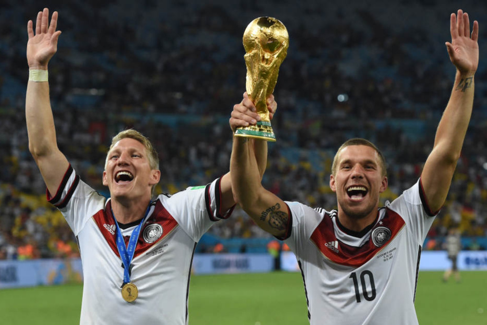 Bastian Schweinsteiger und Lukas Podolski jubeln mit dem WM-Pokal nach dem Finale der Fußball-WM 2014 zwischen Deutschland und Argentinien.