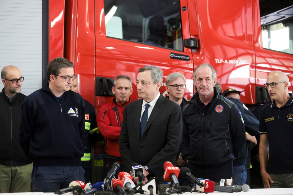 Italy's Prime Minister Mario Draghi (c.) at a press conference with emergency service workers on Monday.