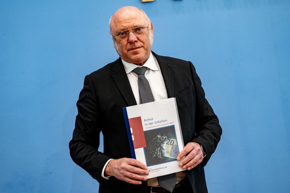 Ulrich Schneider (65) hält während der Bundespressekonferenz des Paritätischen Gesamtverbandes den Bericht zur Armutsentwicklung in der Hand.