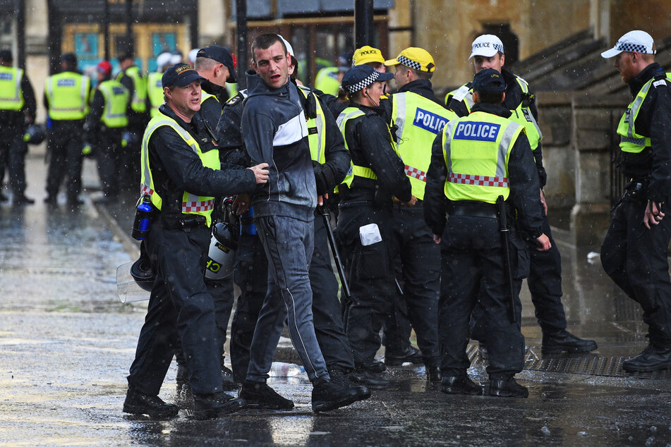 Ein Demonstrant wird in der Nähe der Westminster Abbey in London von der Polizei festgenommen.