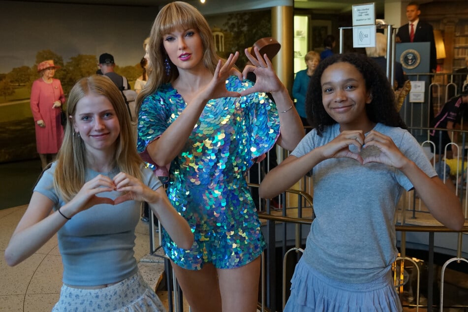 Helen (13, l.) und Mariame (13) zusammen mit ihrem Idol im Panoptikum. Alle drei formen die berühmte Herzpose der Sängerin.