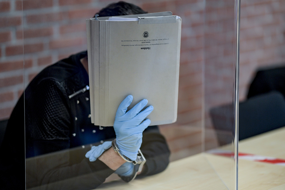 Der Angeklagte im Prozess wegen versuchter Vergewaltigung wartet hinter einer Plexiglasscheibe auf den Beginn der Verhandlung.