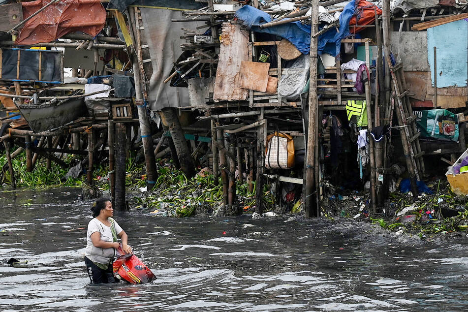 Eine Frau sammelt Plastik ein, nachdem der Taifun durch die philippinische Hauptstadt Manila gezogen ist.