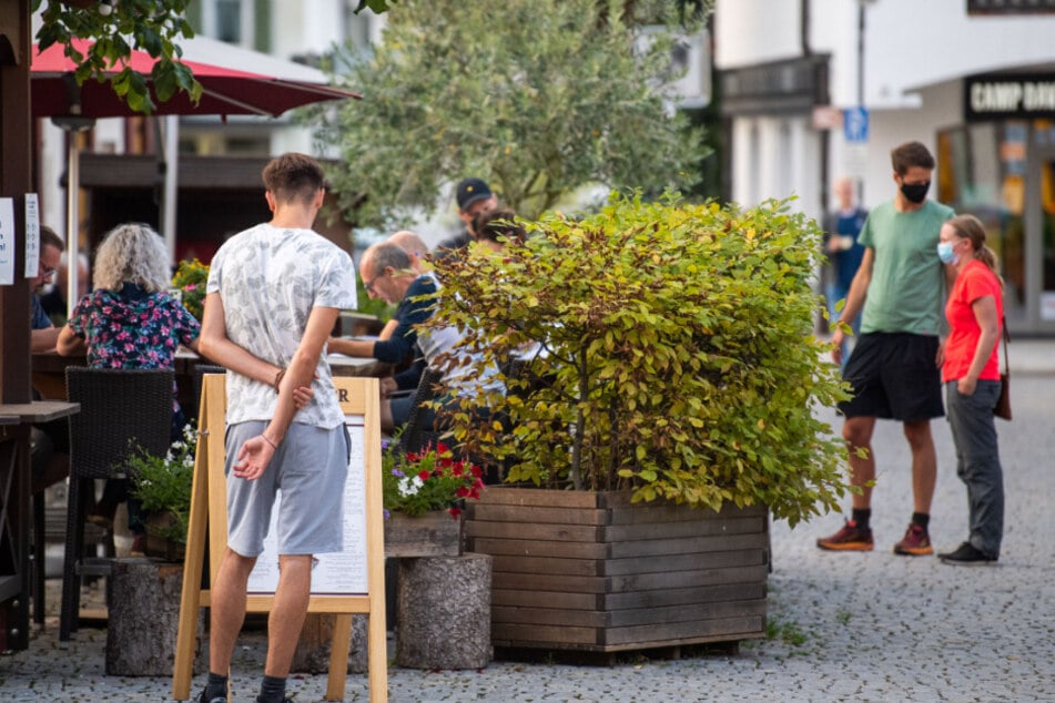 Ein Mann schaut sich eine Speisekarte einer Bar in Garmisch Partenkirchen an.