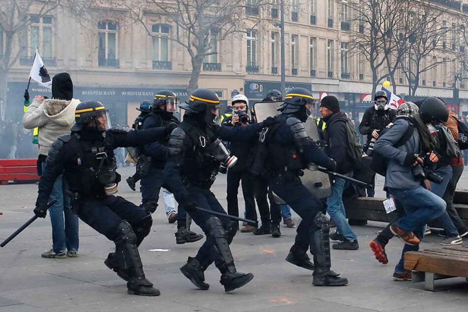 Ein Fotograf bringt sich während der Demos in Sicherheit.