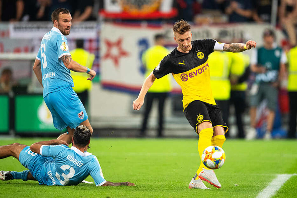 BVB-Kapitän Marco Reus trifft zum 1:0 für Dortmund. Kevin Großkreutz (oben-links) und Selim Gündüz (unten-links) können nicht mehr eingreifen.
