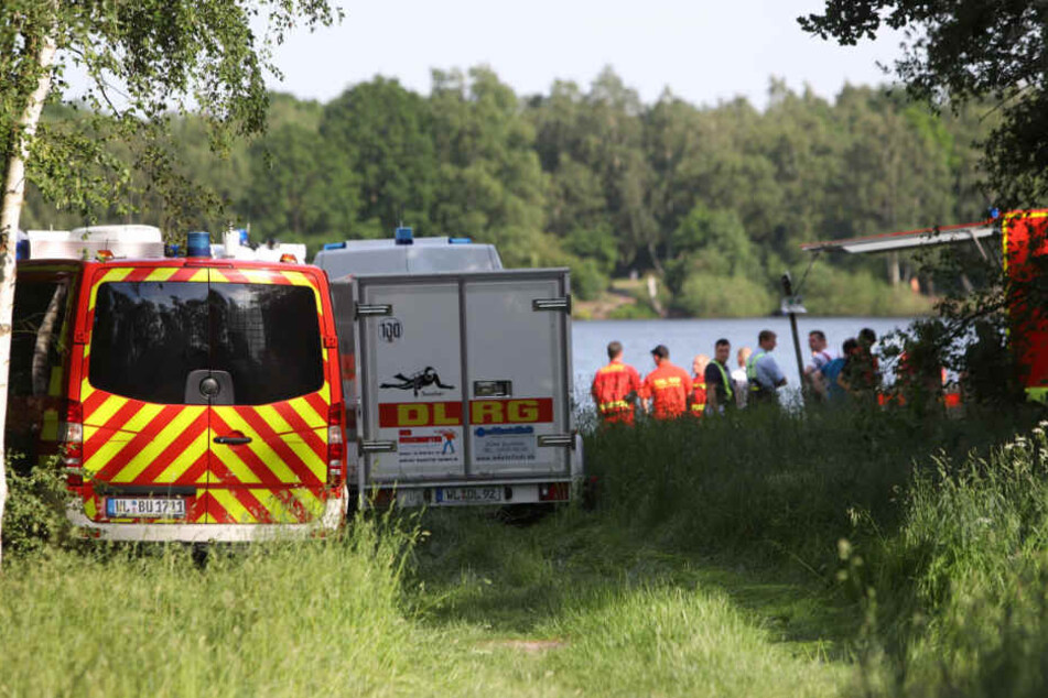 Zahlreiche Einsatzkräfte von Feuerwehr und DLRG suchen am und im See nach dem Schwimmer.