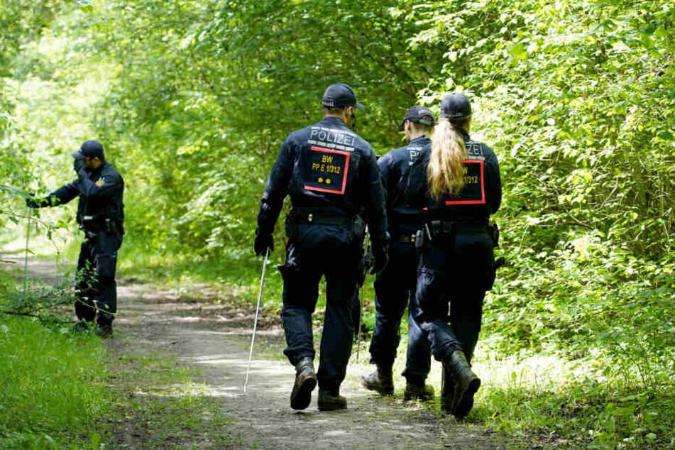 Polizisten suchen die Umgebung nach dem Fund einer Frauenleiche Ende Mai ab.