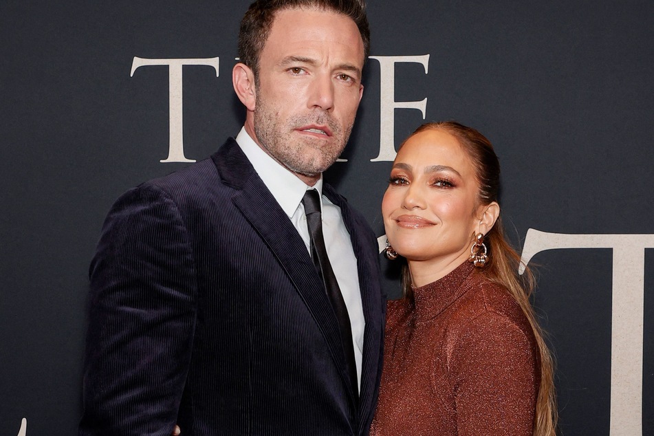 Ben Affleck (l) and Jennifer Lopez couldn't keep their hands off of each other during their holiday party.