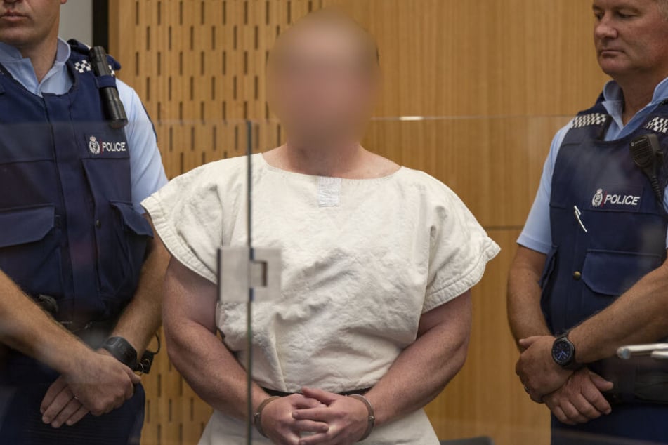 Der mutmaßliche Täter steht mit Handschellen vor einer Anhörung im Bezirksgericht.