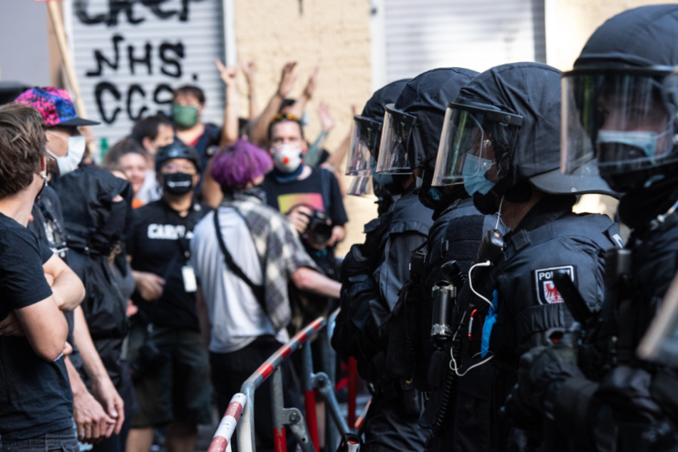 Polizisten und Demonstranten stehen sich gegenüber.