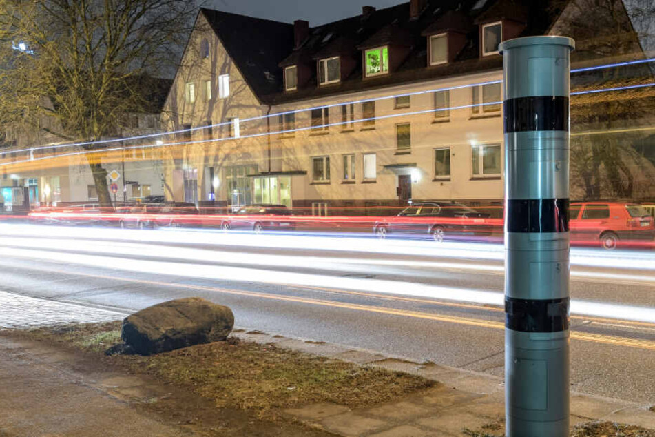 Autos fahren nachts an der Osterfeldstraße an einer stationären Blitzersäule vorbei. (Archivbild)