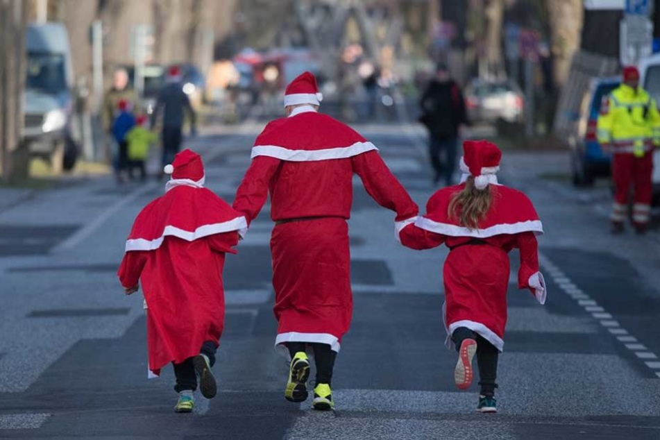 Drei Nikoläuse aus zwei Generationen laufen auf der 2,5 Kilometer langen Strecke dem Ziel entgegen.