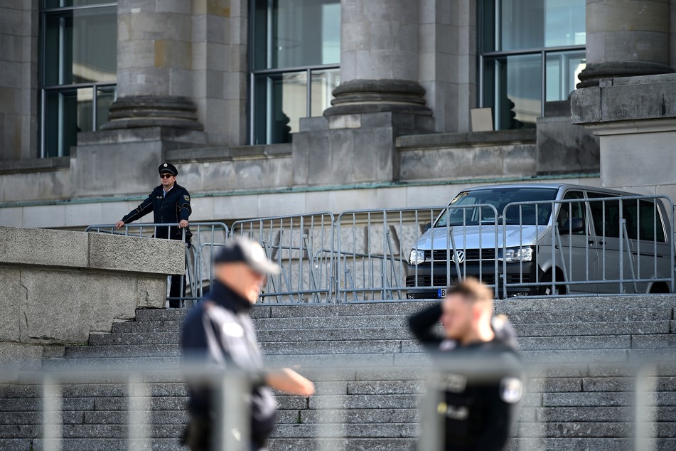 Drei Polizisten stehen vor dem Reichstagsgebäude. Zwei Tage zuvor waren Demonstranten mit Reichsflaggen und rechtsextremen Pöbeleien auf die Treppe des Reichstags gestürmt und nur drei Polizisten hielten die aufgebrachte Menge mit dem Schwenken von Schlagstöcken auf Abstand.