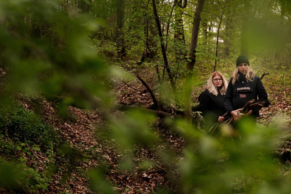 Emely und eine andere Teilnehmerin suchen im Wald nach Material für ihr "Shelter", eine Art Unterschlupf.