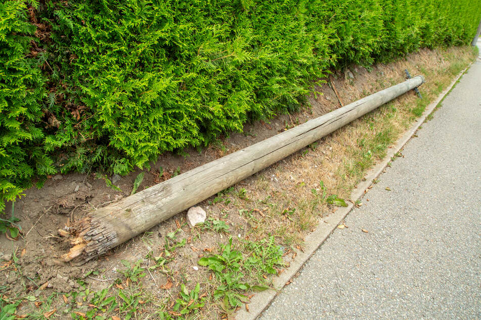 Ein Telefonmast stürzte am Samstag in Zwönitz (Erzgebirge) auf die Straße.