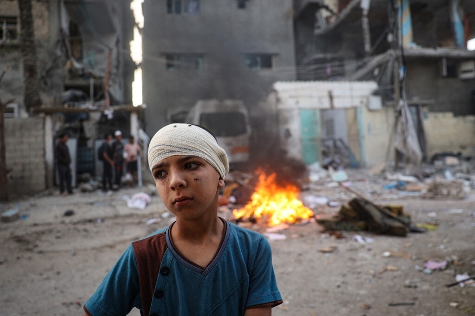 An injured Palestinian boy stands next to the rubble of a family house that was hit overnight in Israeli bombardment in the Tal al-Sultan neighborhood of Rafah in southern Gaza.
