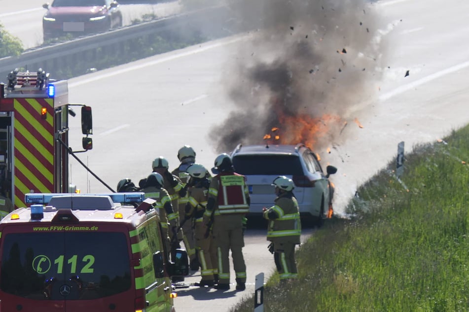 Kameraden der Feuerwehr bei der Löschung des Autos, aus dem zu diesem Zeitpunkt bereits hohe Flammen und dichter Rauch traten.