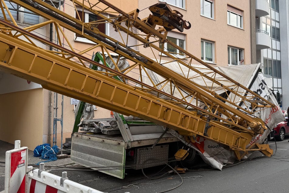 Schreck auf Baustelle: Kran kippt um und macht Laster platt