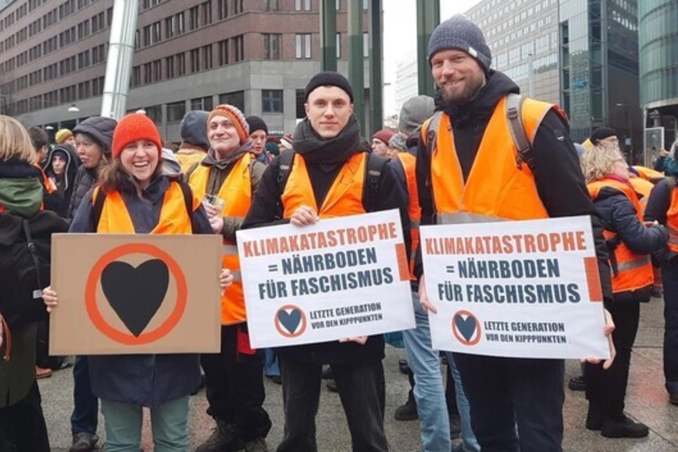 Aktivisten der "Letzten Generation" halten in Berlin Banner vor sich und demonstrieren gegen Faschismus.