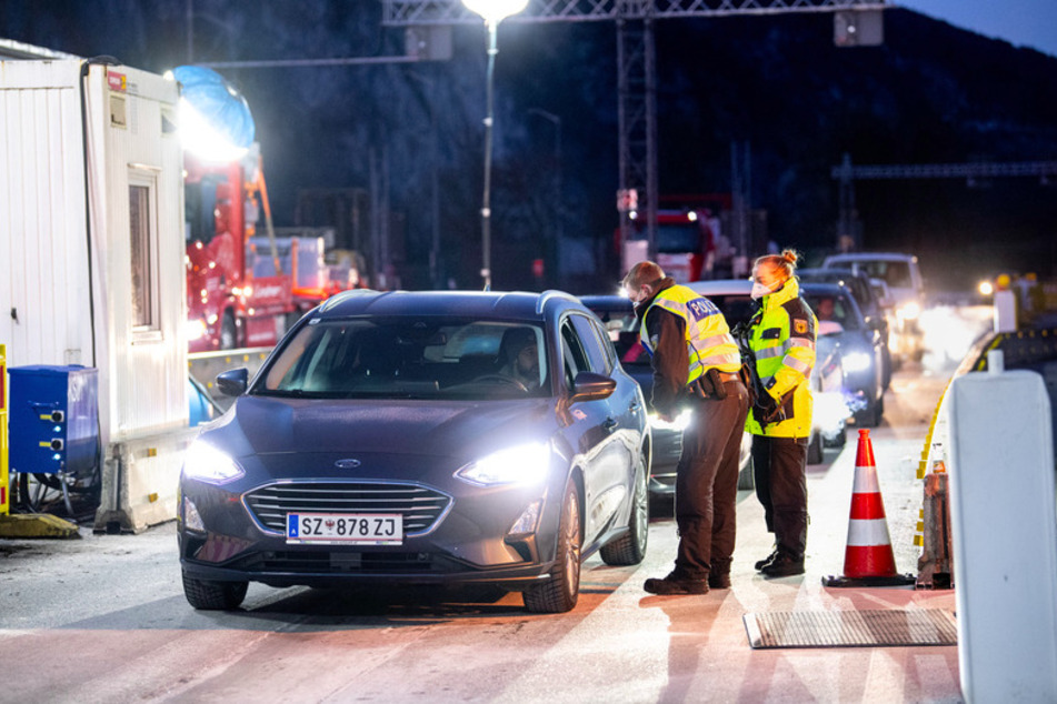 Zwei Bundespolizisten kontrollieren die Dokumente von Reisenden an der Autobahn A93 bei Kiefersfelden in Richtung Deutschland.