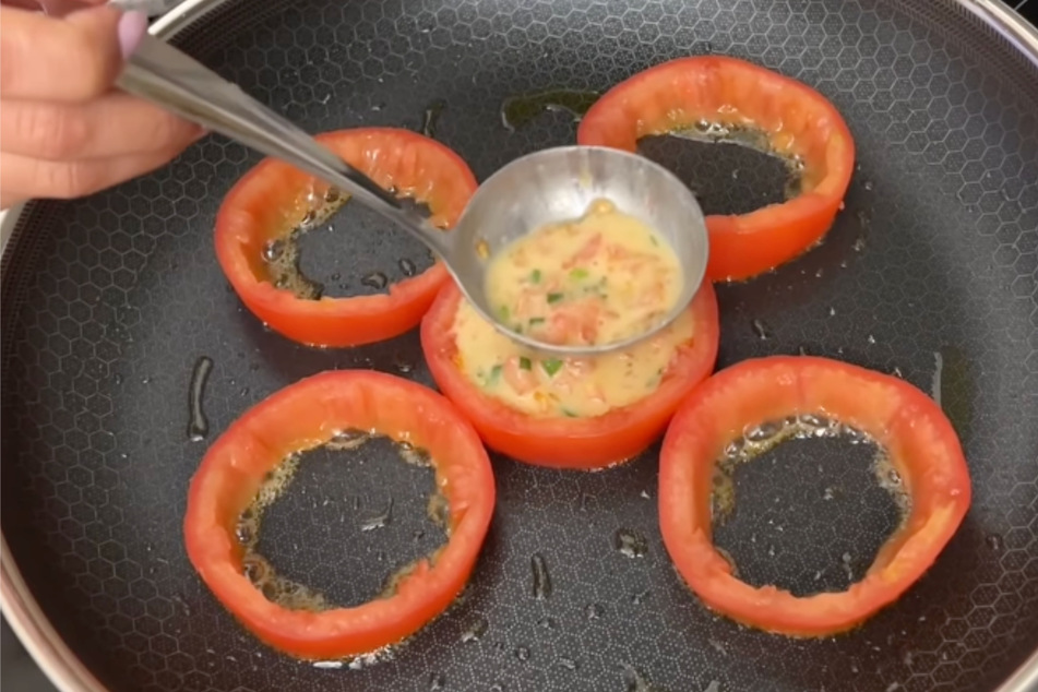Alles brutzelt in der Pfanne: Die Tomatenringe werden nun mit "Leben" gefüllt.