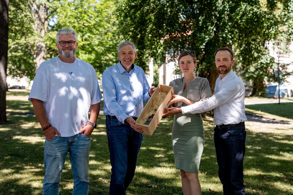 Die bisherigen Kola-Chefs Luise Günther und Jakob Weiß (r.) übergeben den Geschäftsführern der SFZ-Gruppe, Dirk Glowka (l.) und Axel Brückom, symbolisch die erste Flasche.