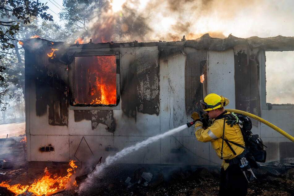 Feuerwehrmann Gus Laws löscht die Flammen an einem Haus.