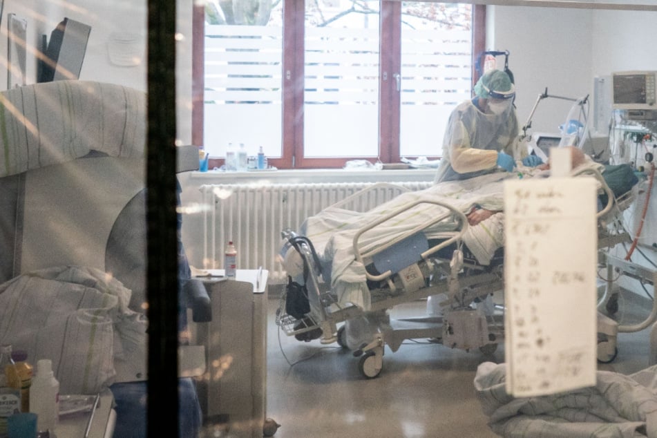 Ein Krankenpfleger behandelt einen Corona-Patienten auf der Intensivstation einer Klinik.