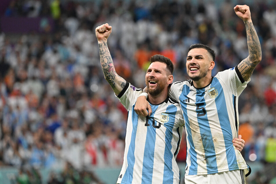 Argentina's forward Lionel Messi (l) and midfielder Leandro Paredes celebrate after qualifying for the Qatar World Cup semifinals.