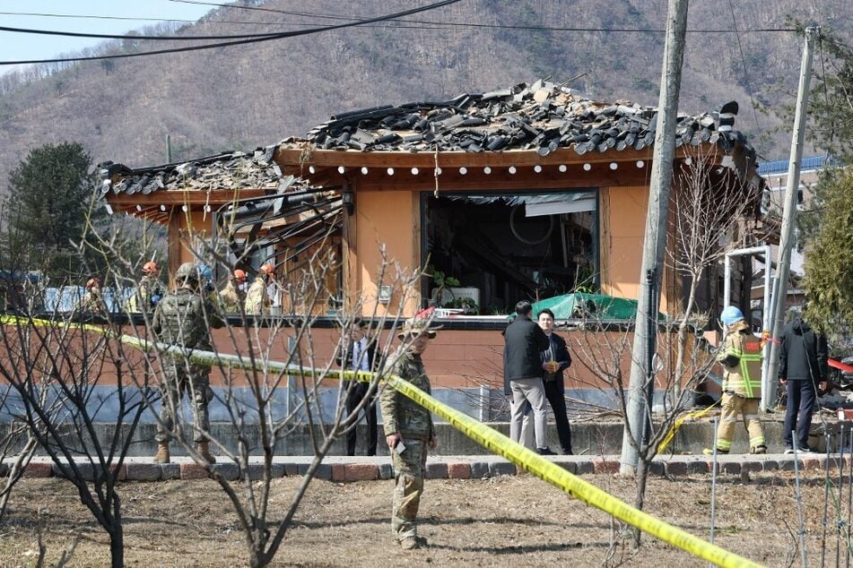 South Korean soldiers and rescue workers inspect a damaged house after a bomb accident at a village in Pocheon on March 6, 2025.