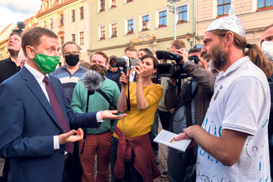 Auch mit sprichwörtlichen "Aluthut-Trägern", wie hier in Pirna, redet der Regierungs-Chef.