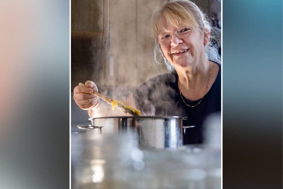 Über dem dampfenden Topf probiert Beate Groß, damit die Orangenstücke am Ende nicht zu fest und nicht zu weich sind.