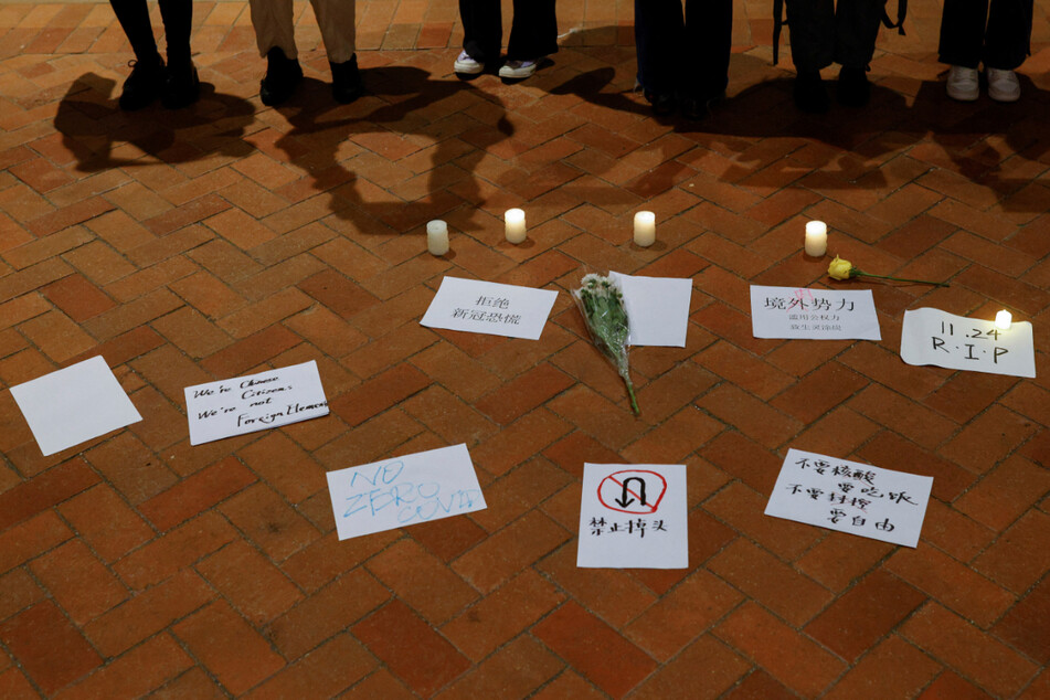 People held sheets of paper in protest over Covid-19 restrictions in China during a vigil for of the victims of a fire in Urumqi, which killed 10.