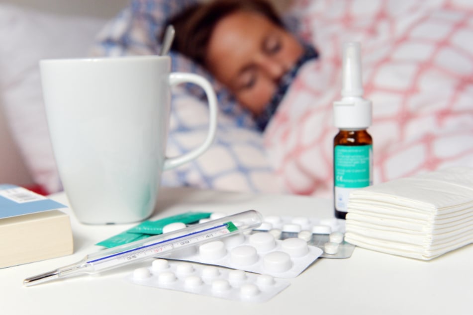 Eine Frau liegt mit einer Influenza im Bett. (Symbolbild)