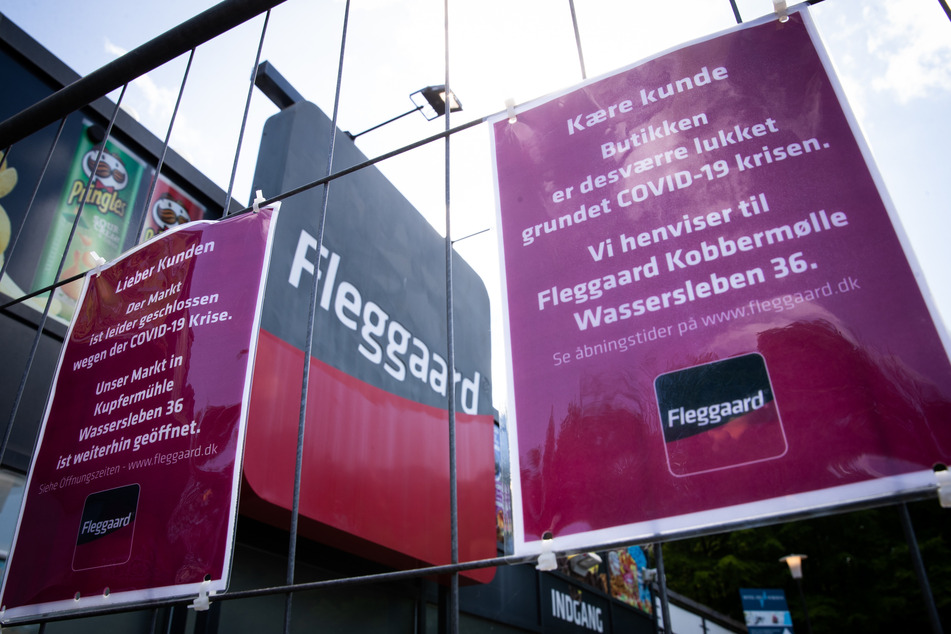 Ein Schild mit der Aufschrift "Liebe Kunden, der Markt ist leider geschlossen wegen der Covid-19 Krise." hängt vor dem verschlossenen und mit einem Zaun gesicherten Haupteingang einer Filiale der dänischen Supermarktkette Fleggaard. Umsatzeinbußen verzeichnen dieser Tage wohl die meisten Einzelhändler überall im Land. In der Grenzregion zu Dänemark leidet eine Branche ganz besonders: Die Grenzhändler, die überwiegend von skandinavischen Kunden leben.