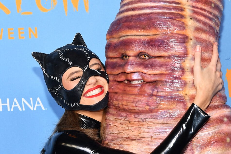 Heidi (r) and Leni Klum (l) dressed up as Catwoman and a huge worm at Heidi's annual Halloween party.