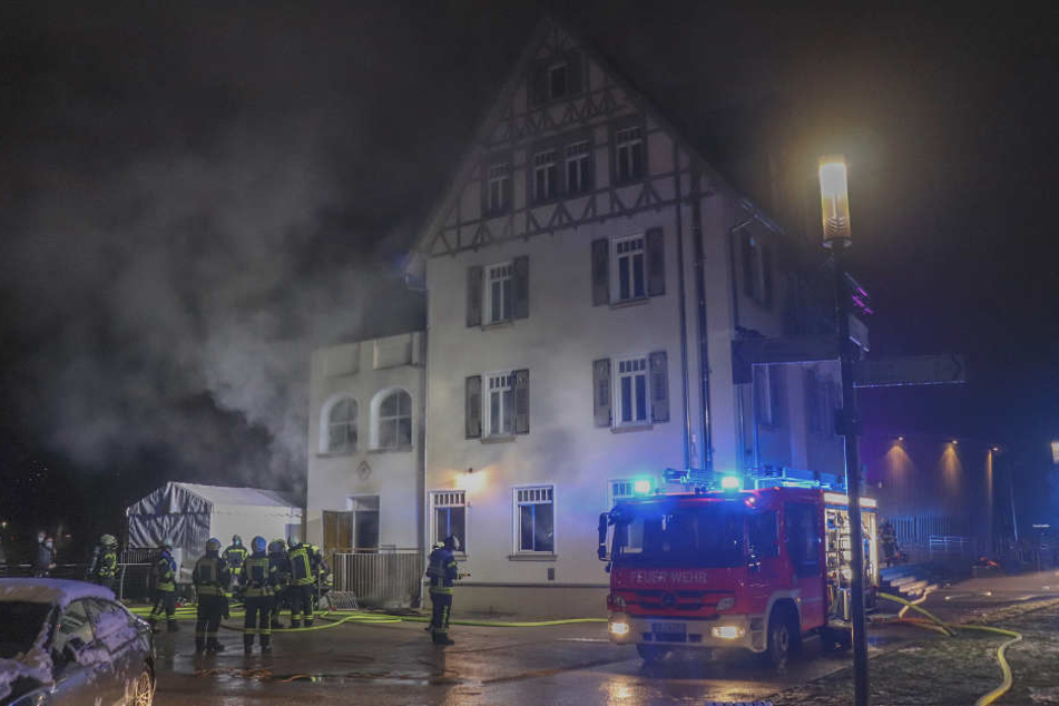 Feuerwehrleute stehen bei Löscharbeiten vor einem Hotel am Remspark in Schwäbisch Gmünd (Ostalbkreis).