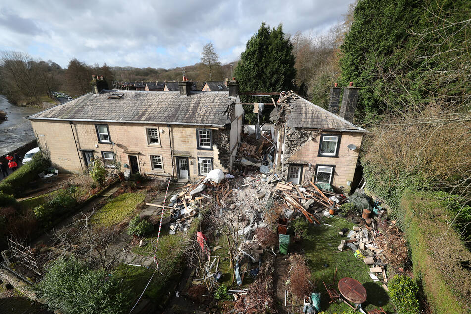 Ein Wohnhaus in der Nähe von Manchester ist durch eine Explosion zusammengebrochen und hat eine Frau unter den Trümmern vergraben.