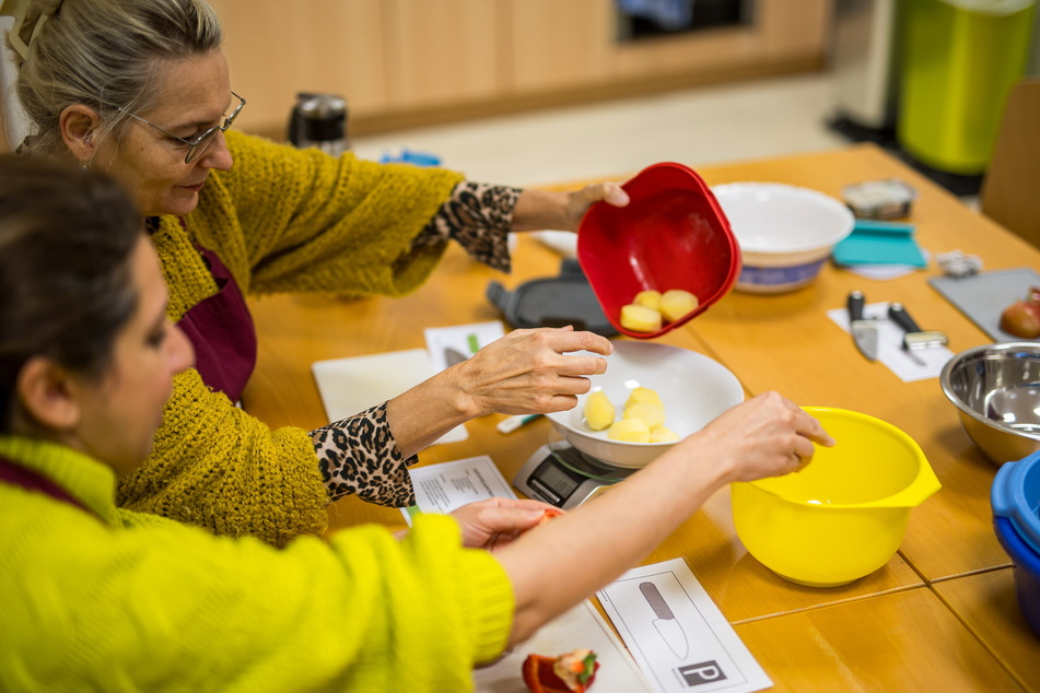 Selbst machen macht Appetit: Die Kursteilnehmerinnen Rand Al-Sabar (42, v.) und Brunhild Fischer (61) setzen die Tipps und Tricks gleich selbst am Küchentisch um.