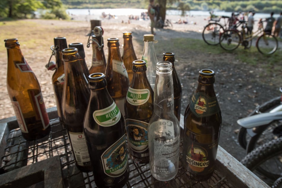 Leere Bierflaschen stehen am Flaucher an der Isar auf einem Abfallcontainer.