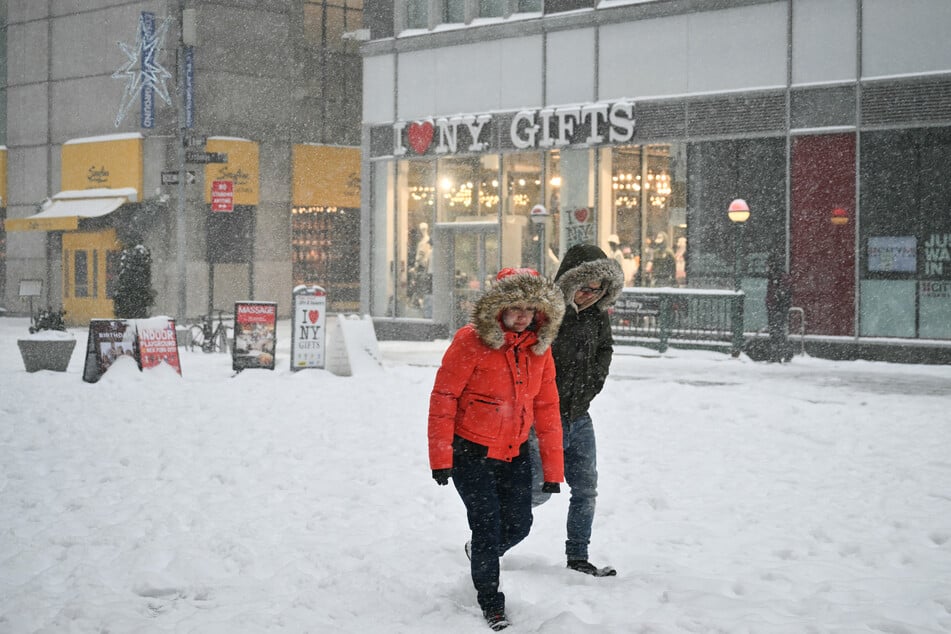 People walk through the snow in New York City on Sunday.
